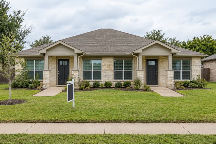 Duplex with two front entrances and a yard sign